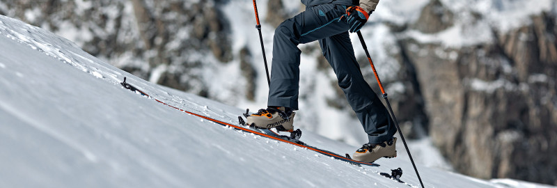 ski touring enthusiast on the ascent with a snow-covered mountain backdrop